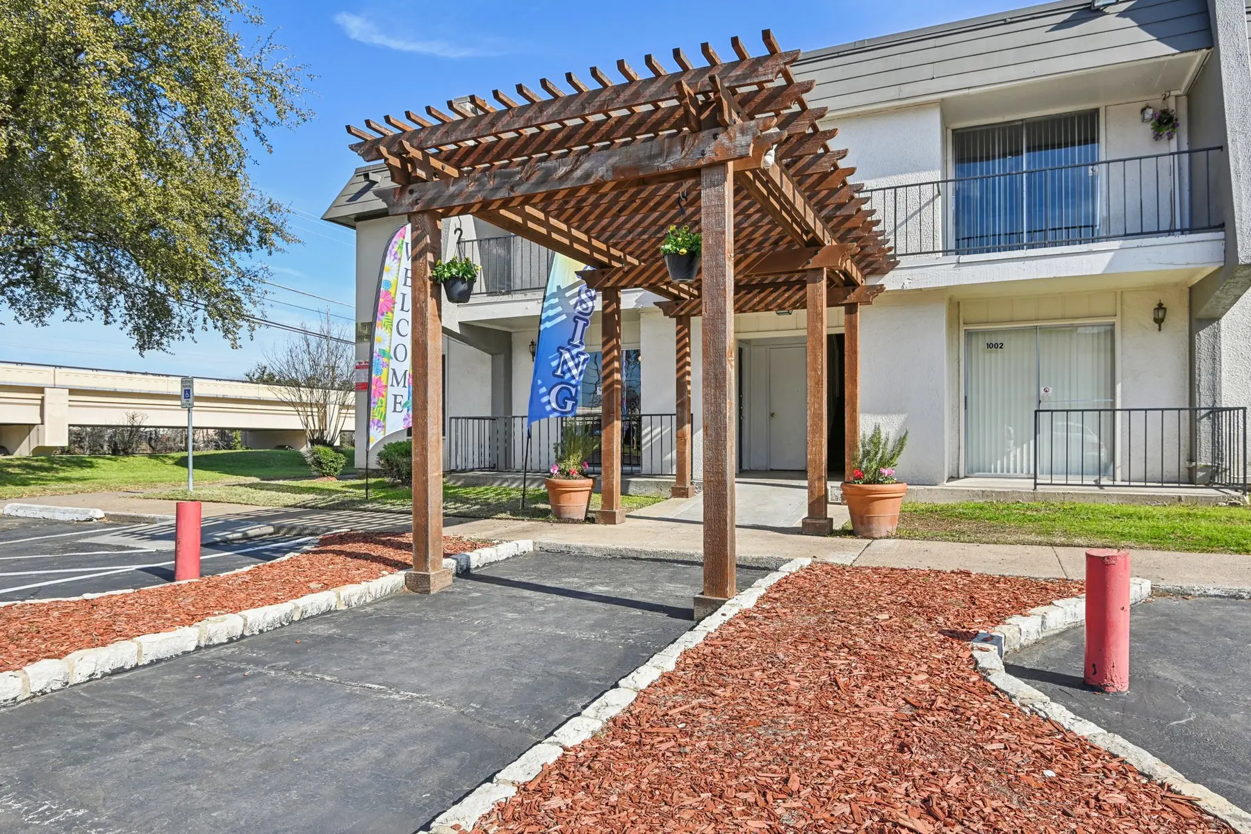 A welcoming entrance area with a wooden pergola and decorative flags.