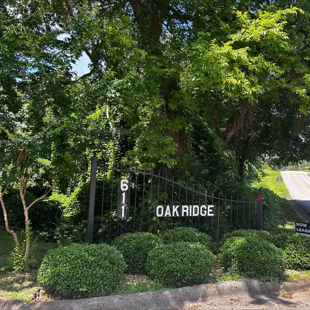 Entrance to Oak Ridge Entrance sign for Oak Ridge with the number 611 visible, surrounded by greenery and bushes.