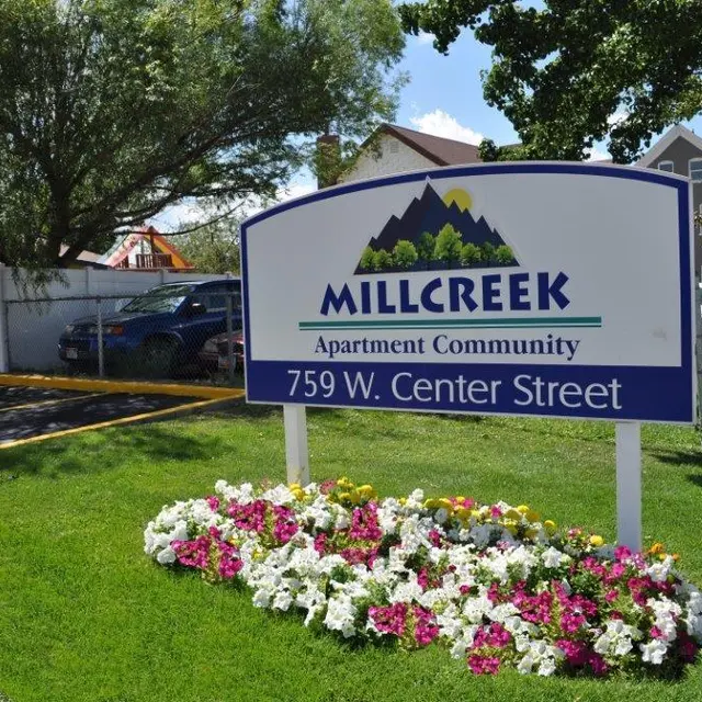 Sign for Millcreek Apartment Community with flowers in front, located at 759 W. Center Street.
