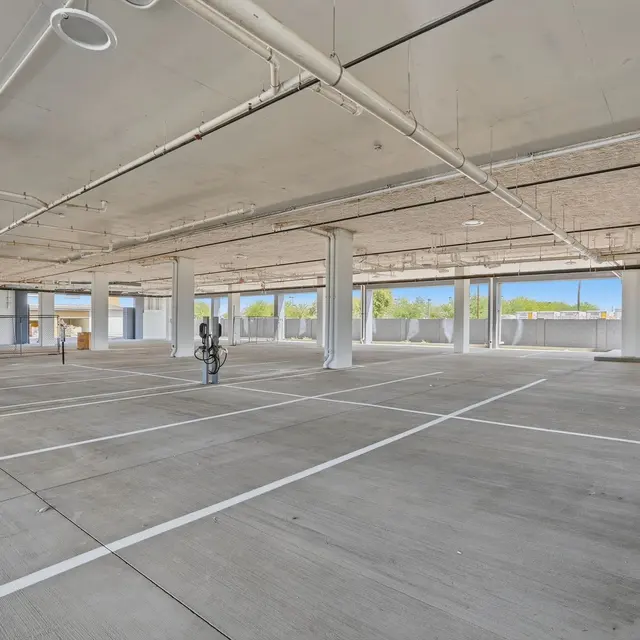 An empty parking garage with multiple parking spaces and electric vehicle charging stations.