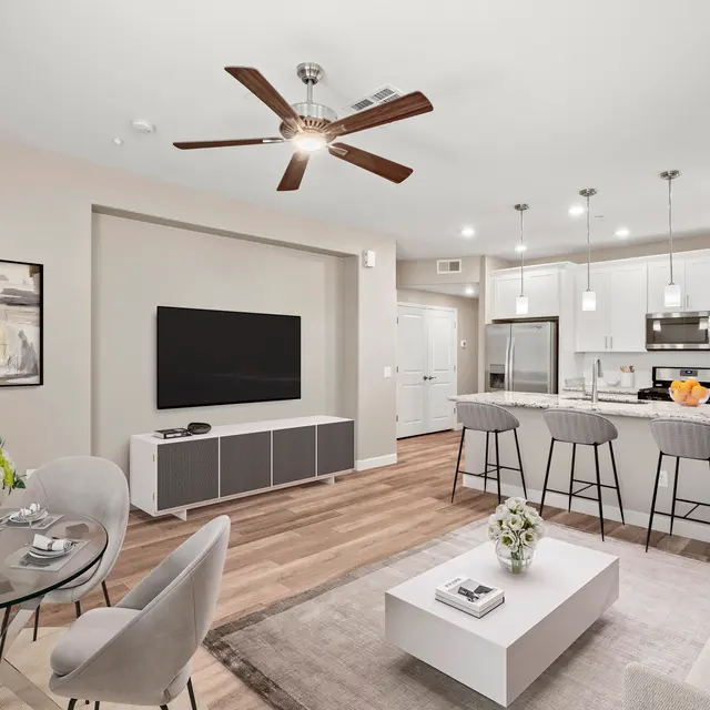 A modern living room featuring a cozy seating area, dining table, and kitchen with sleek appliances.