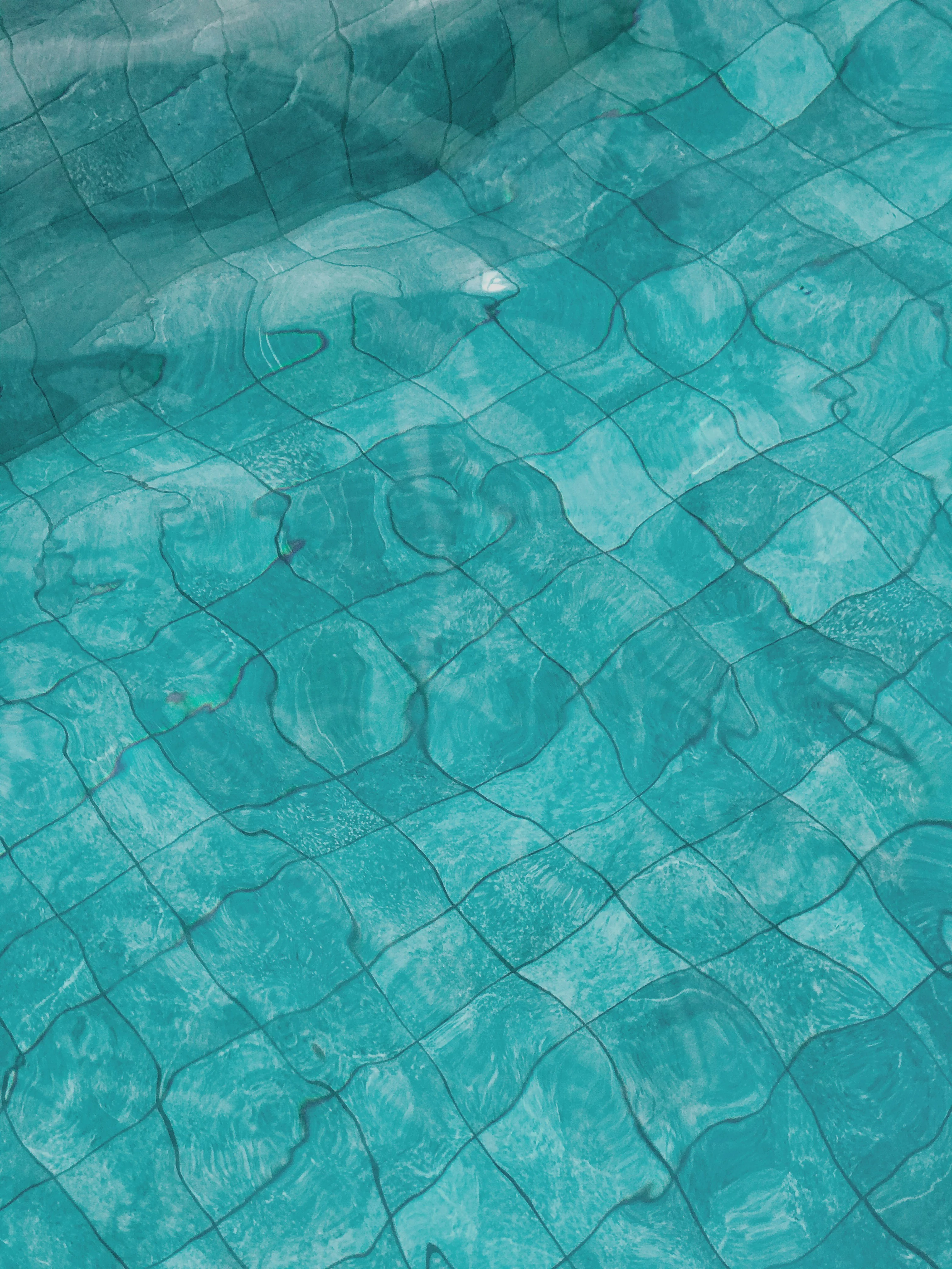 Close-up view of textured blue pool water with light reflections.