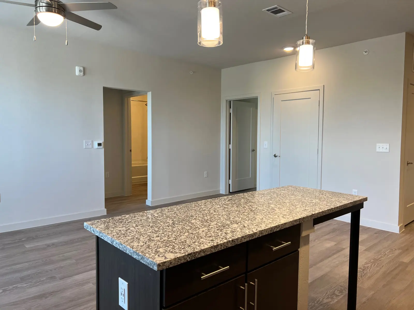 Modern apartment interior featuring an open living space with a kitchen island and natural light.