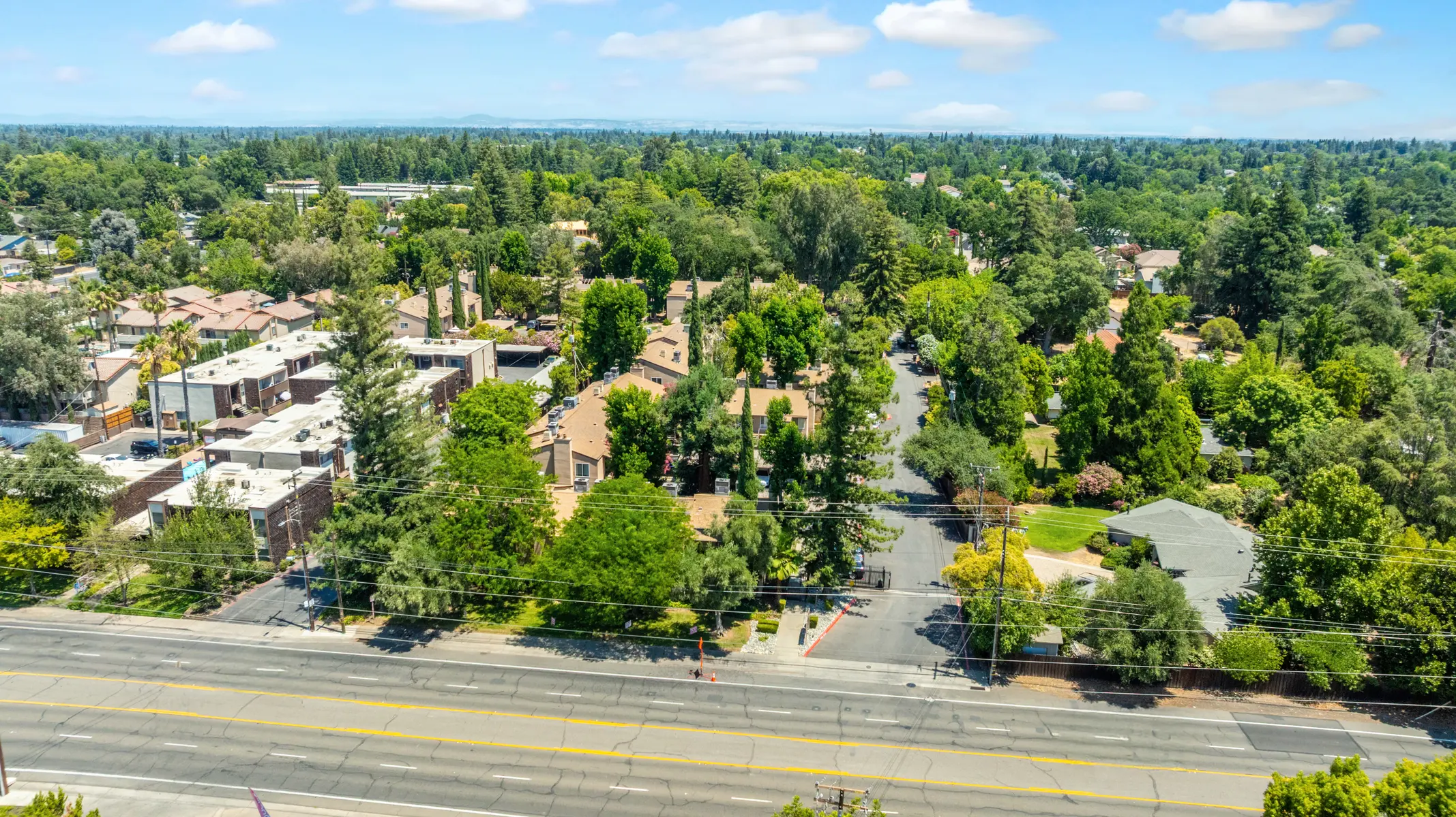 Aerial view of a suburban area featuring homes, greenery, and a road