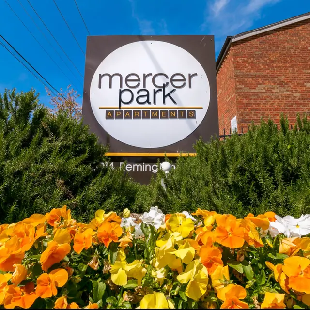 Sign for Mercer Park Apartments surrounded by colorful flowers