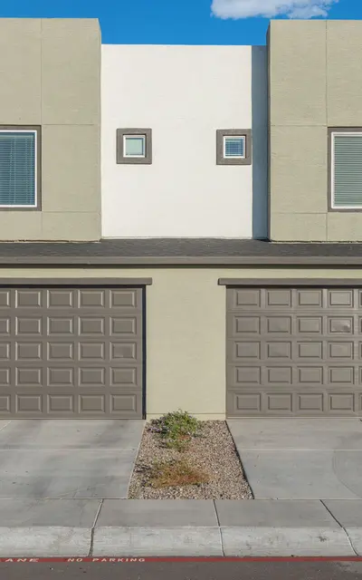 Modern Townhouse Exterior Exterior view of a modern townhouse, featuring a two-unit design with garages and landscaped front area.