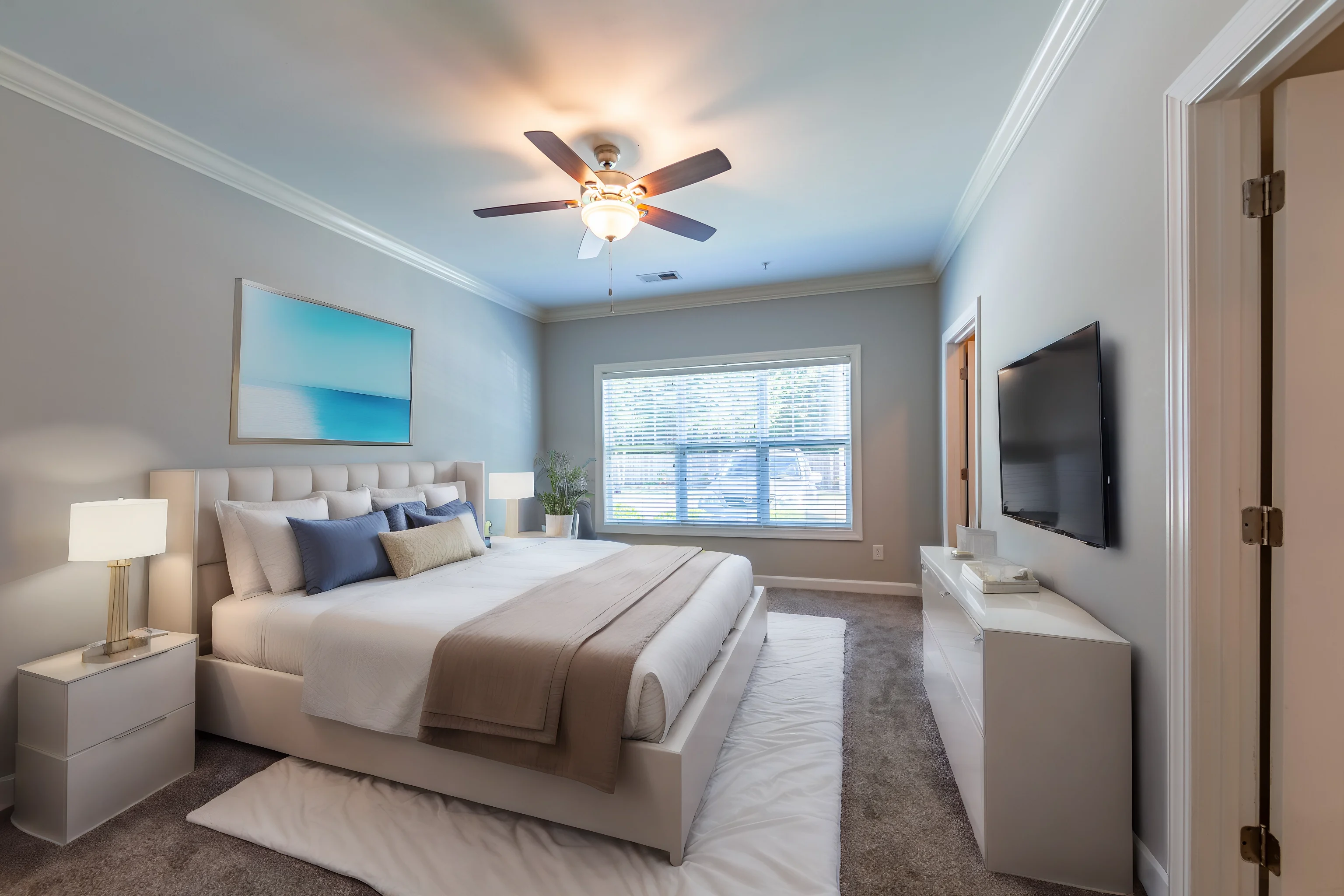 Stylish Modern Bedroom Interior A modern bedroom featuring a large bed with neutral bedding, two nightstands with lamps, a wall-mounted TV, and a sunny window with a view.