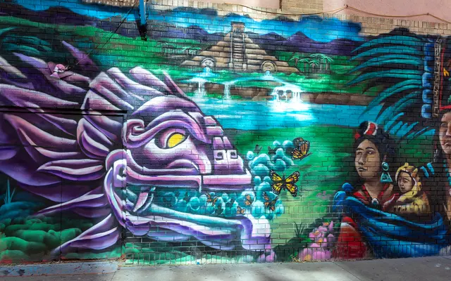 VIBRANT ENERGY A vibrant mural depicting a colorful dragon-like serpent alongside two figures holding a child, a lush landscape, and a pyramid in the background with waterfalls. Butterflies can be seen fluttering near the serpent's mouth.