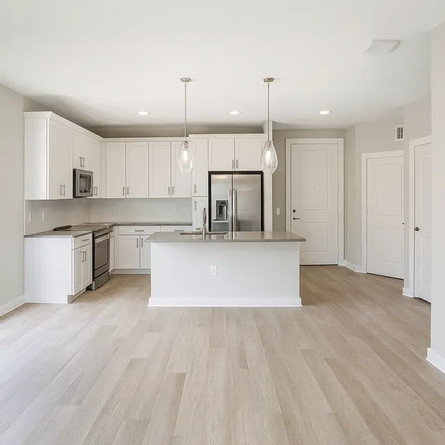 Modern Kitchen Design A modern kitchen with white cabinets, stainless steel appliances, and pendant lighting. The floor is light-colored wood, and the space is bright and spacious with an open layout.