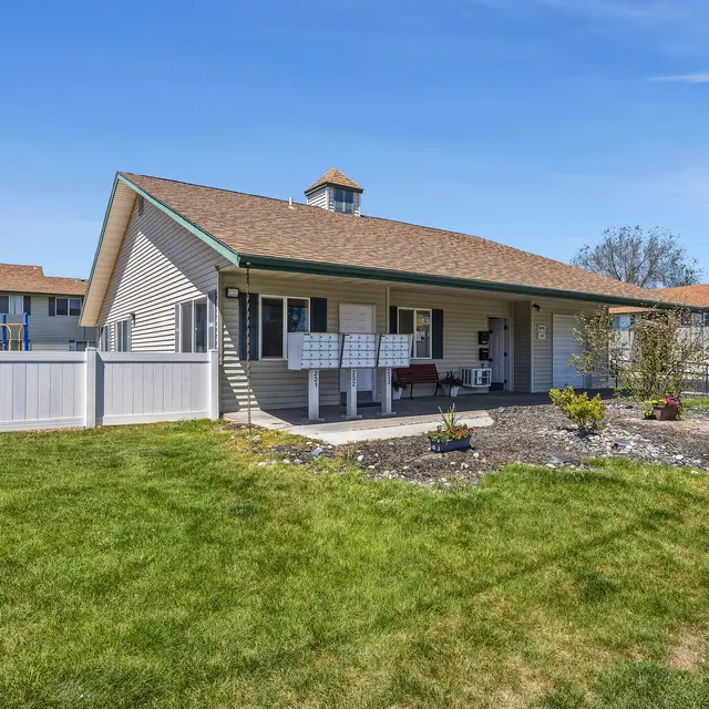 Residential Property with Playground View of a single-story residential property with a lawn, mailbox, and a playground in the background.