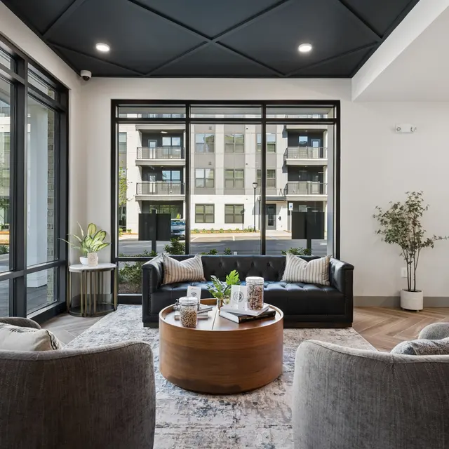 Modern Communal Living Space A modern communal living space with large windows, featuring comfortable seating and decorative elements.
