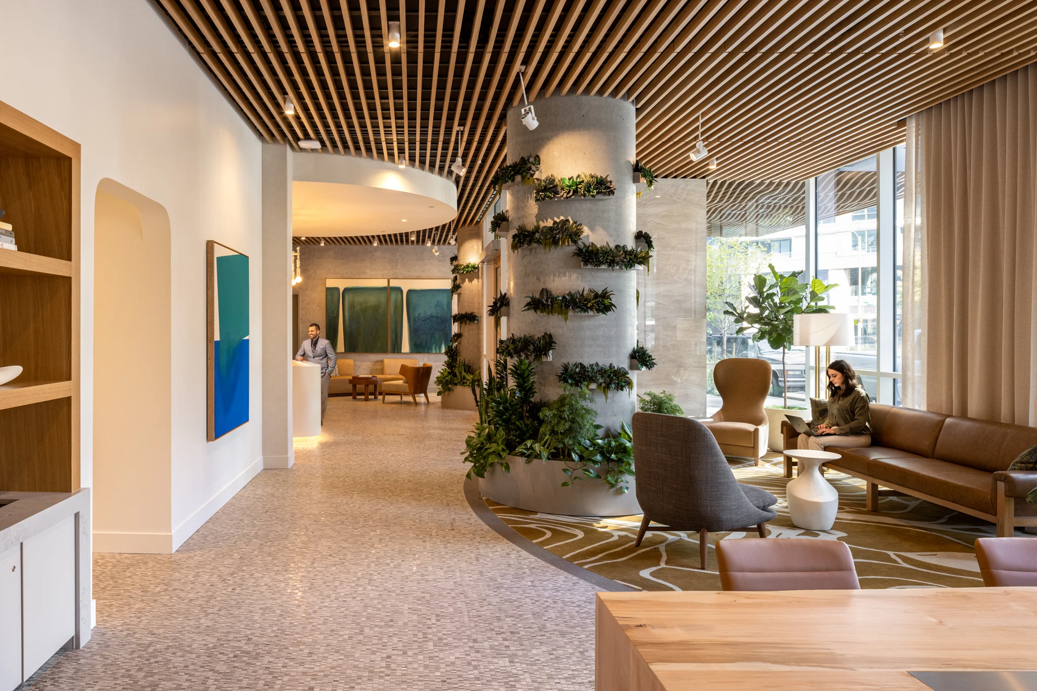 1075 Lenora - The Ivey Lobby A modern lobby with wooden ceiling, plants, comfortable seating and artwork.