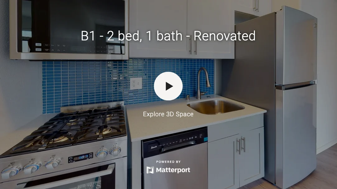 A renovated kitchen featuring a gas stove, stainless steel refrigerator, and blue backsplash tiles.