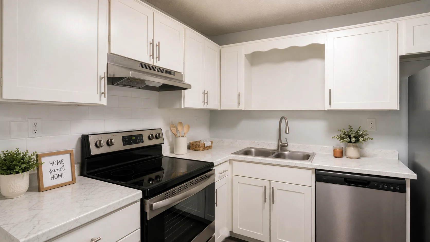 Modern Kitchen Design A modern kitchen featuring white cabinets, a stainless steel fridge, a black stove, and marble countertops. Decorative items are placed on the countertops.