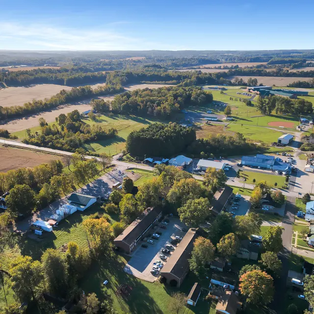 Aerial view of a rural town with fields, trees, and buildings