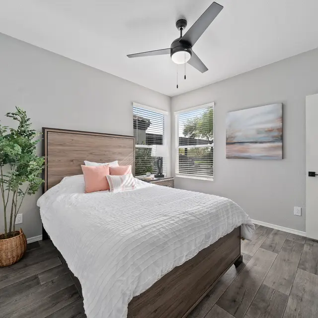 Comfortable bedroom with large window, neutral finishes, and walk-in closet at Bear Canyon Apartments