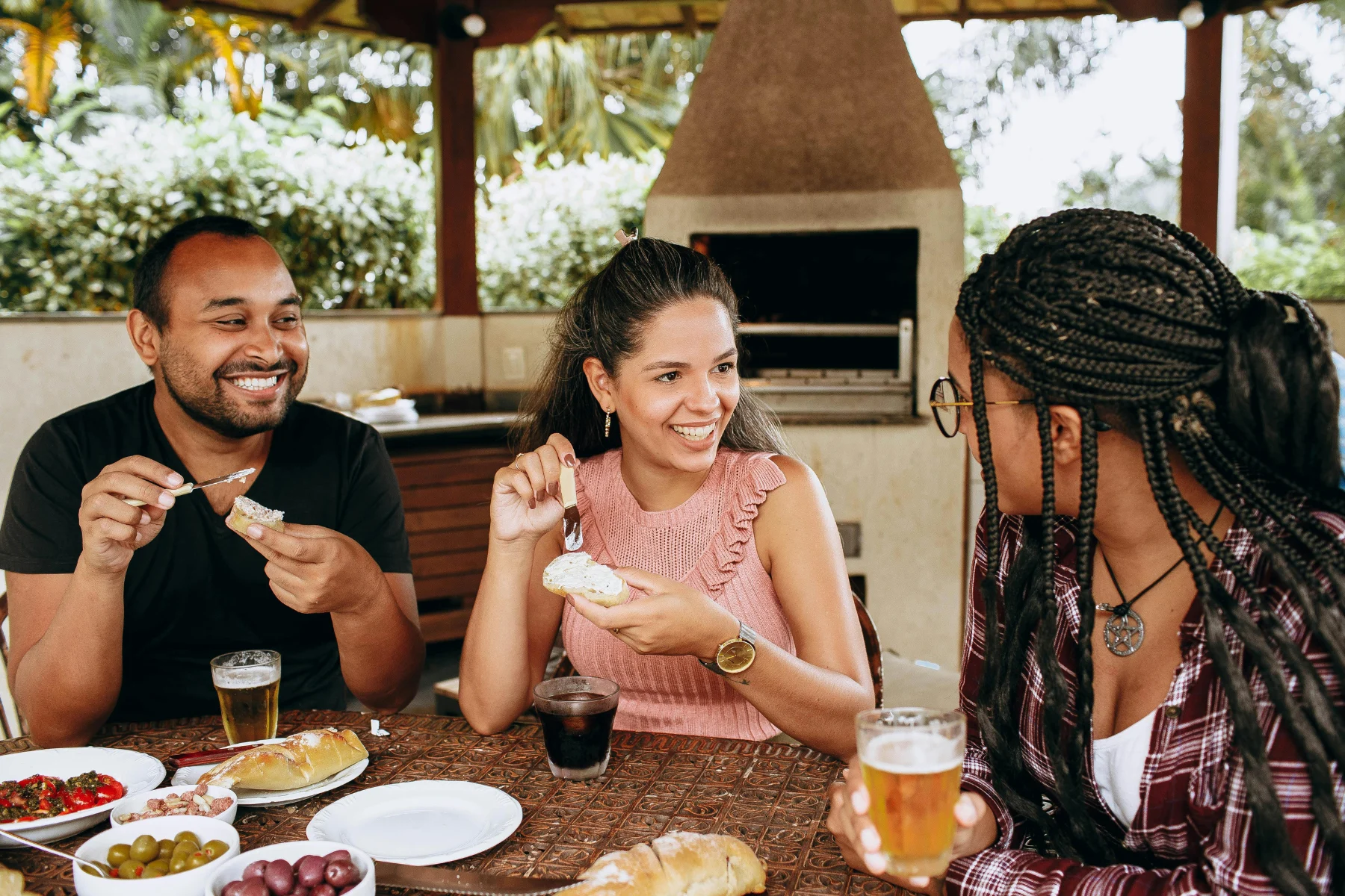 Outdoor Dining with Friends Three friends sharing a meal outdoors, laughing and enjoying each other's company.
