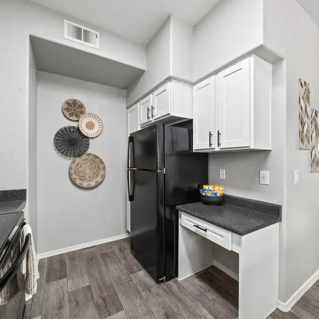 Contemporary kitchen with breakfast bar, upgraded appliances, and open layout at Bear Canyon Apartments