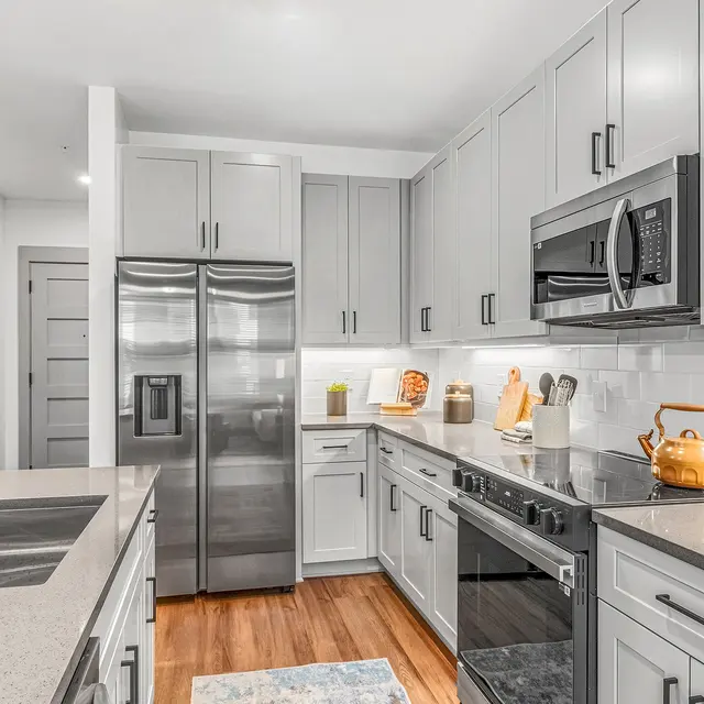 Contemporary Kitchen Design A contemporary kitchen featuring gray cabinets, stainless steel appliances, and a large island with a sink.