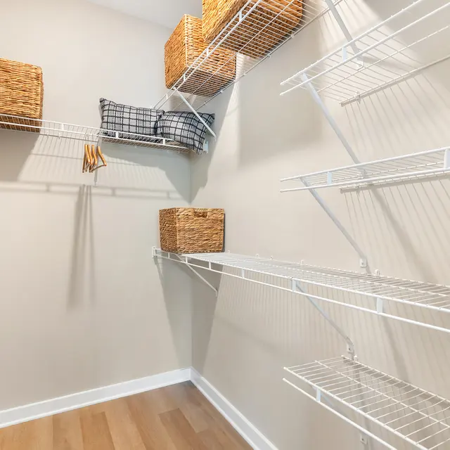 An organized closet with wire shelving and storage baskets.