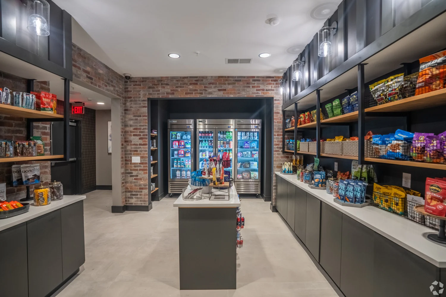 A well-organized modern convenience store with shelves stocked with snacks, drinks, and other products. The space features a cool color palette and contemporary design elements, with brick accents and well-lit shelves.