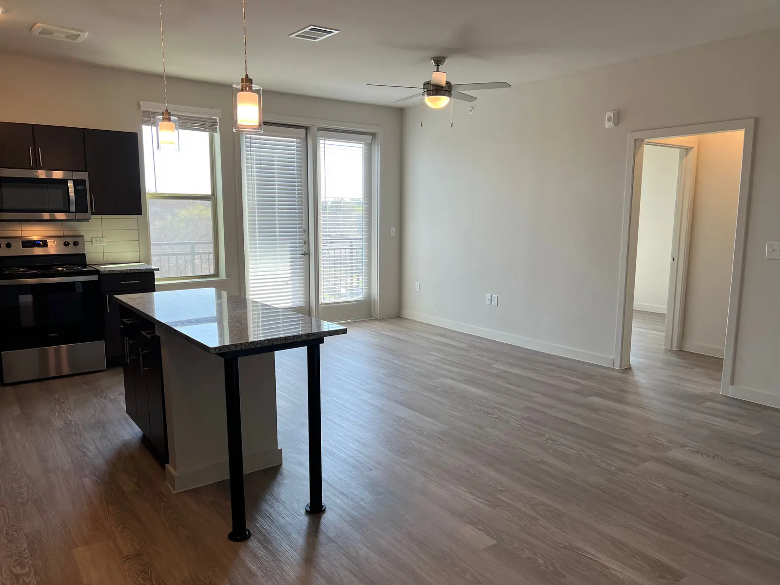 Contemporary Apartment Interior A modern kitchen and living area with an island, stainless steel appliances, and large windows that let in natural light.