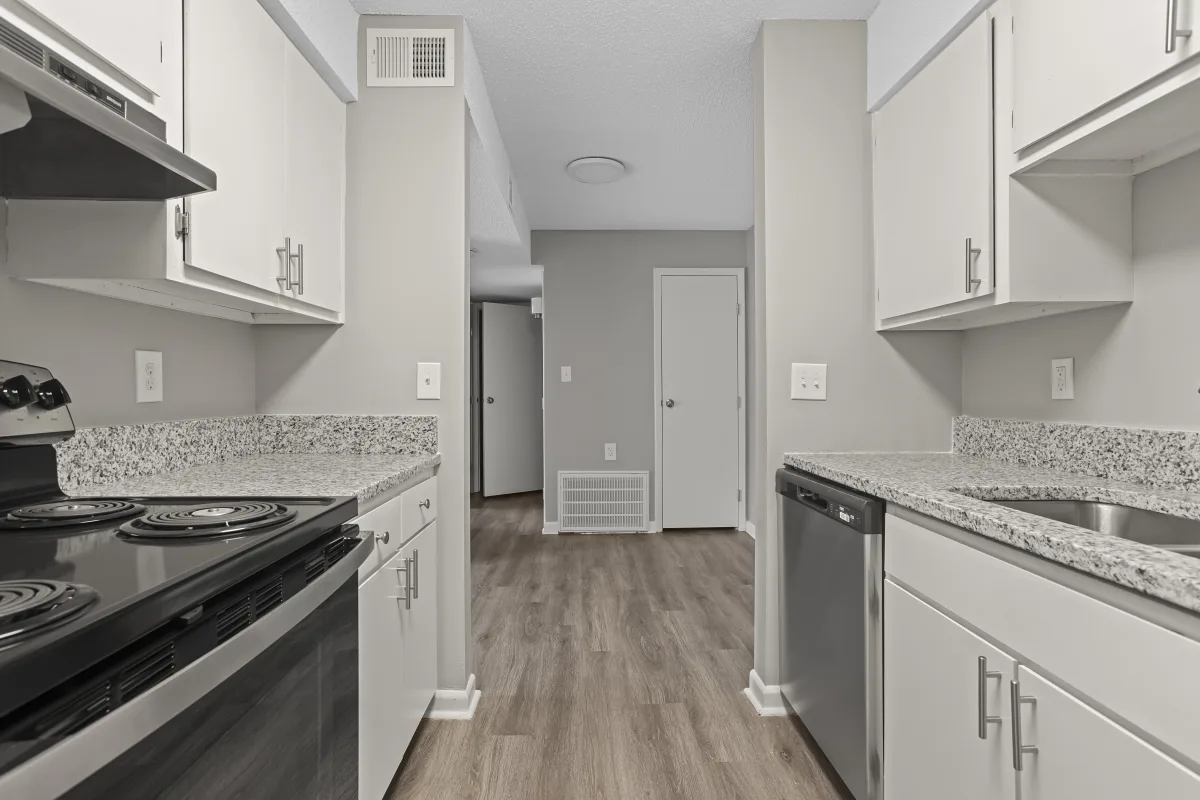 Modern Kitchen Design A modern kitchen featuring light-colored cabinets, granite countertops, and stainless-steel appliances. The view is from the entry of the kitchen looking towards an adjacent room.