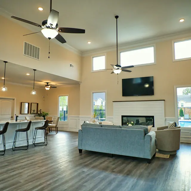 Spacious modern living room with high ceiling, natural light, and elegant furnishings.