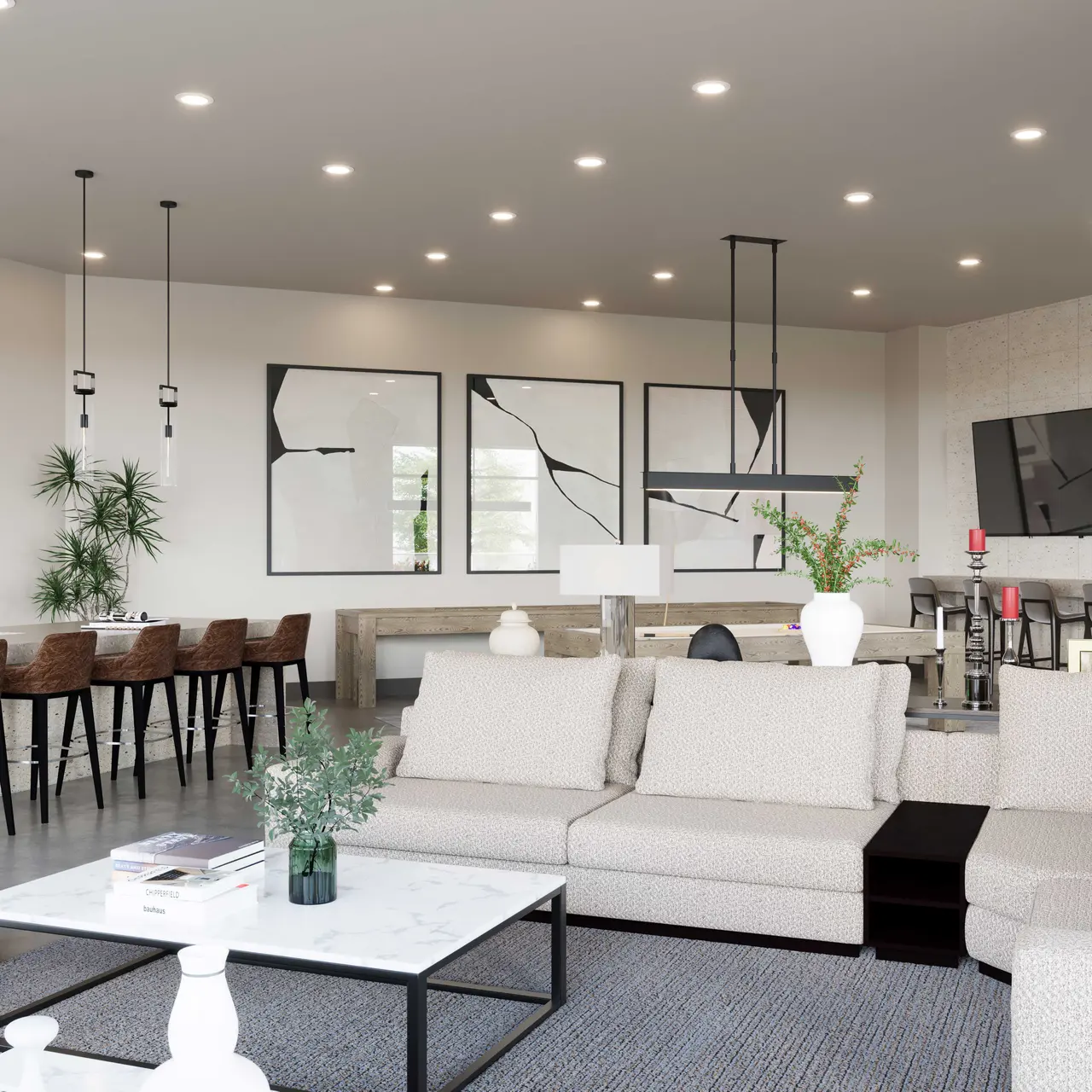 A modern living space featuring a light-colored sofa, coffee table, and dining area with wooden stools. The walls are adorned with abstract art and there are multiple light fixtures overhead, along with potted plants for decoration.