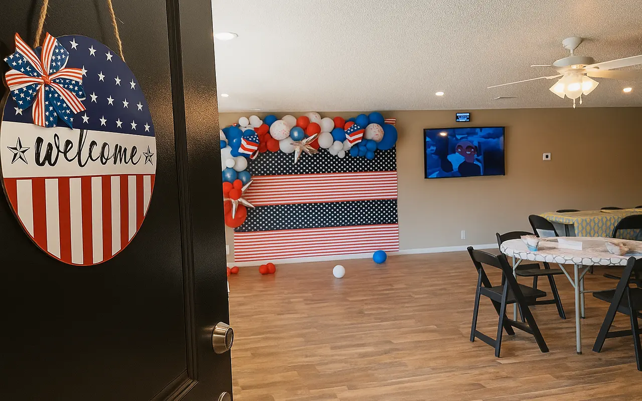 A welcoming entrance to a decorated indoor event space featuring patriotic-themed decorations including balloons and a 'Welcome' sign.