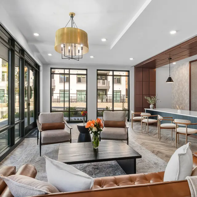 Stylish Modern Lobby A modern lobby space featuring stylish brown and gray furniture, large windows allowing natural light, and a reception counter with plants in the background.
