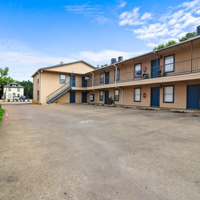 View of an apartment complex with two buildings and an open courtyard area.