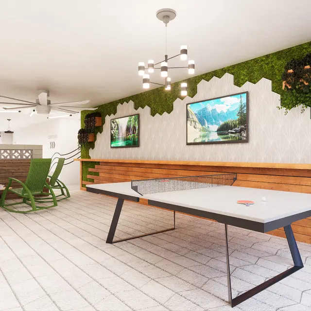 A modern recreational area featuring a ping pong table, a green rocking chair, and wall decor with plants and pictures of nature.