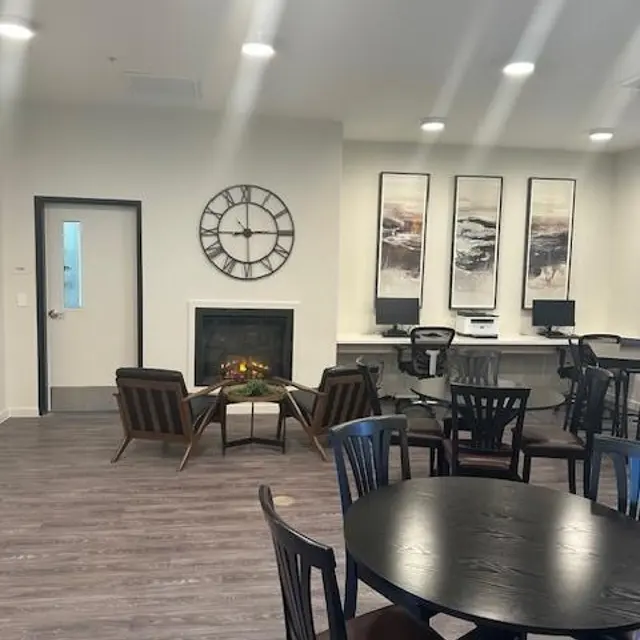 Cozy Lounge and Dining Area A cozy lounge area featuring a fireplace, modern decor, and a dining space with circular tables and wooden chairs.