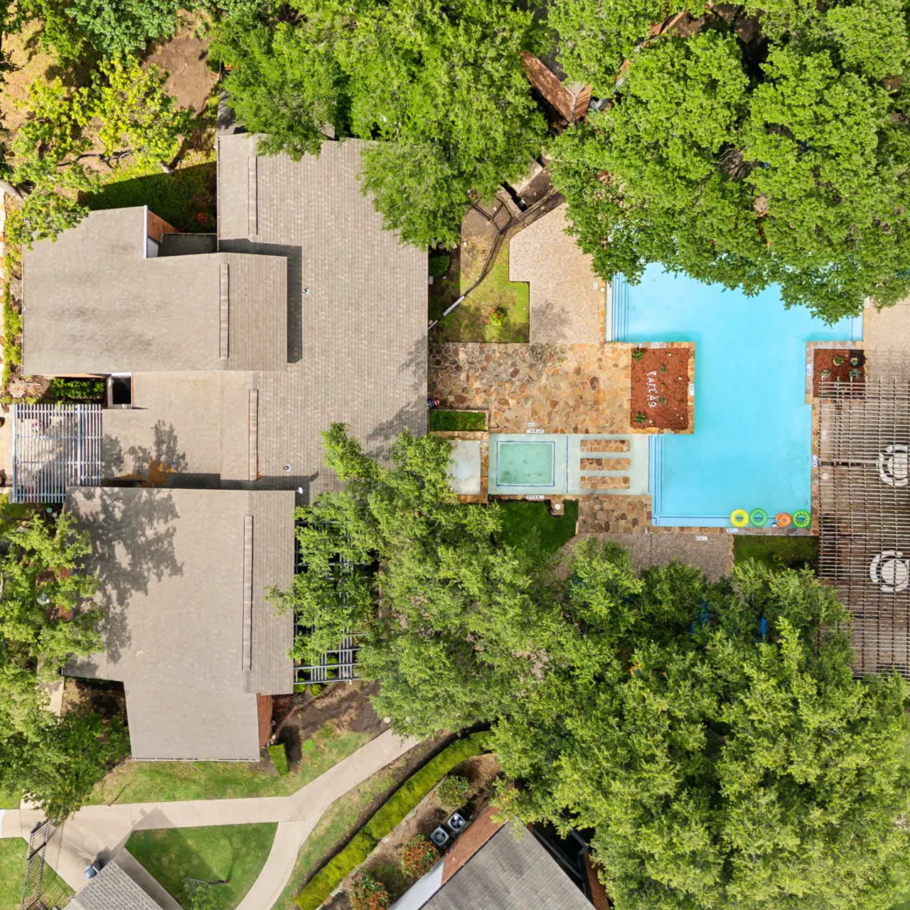 Aerial view of a resort featuring a swimming pool and surrounding greenery.