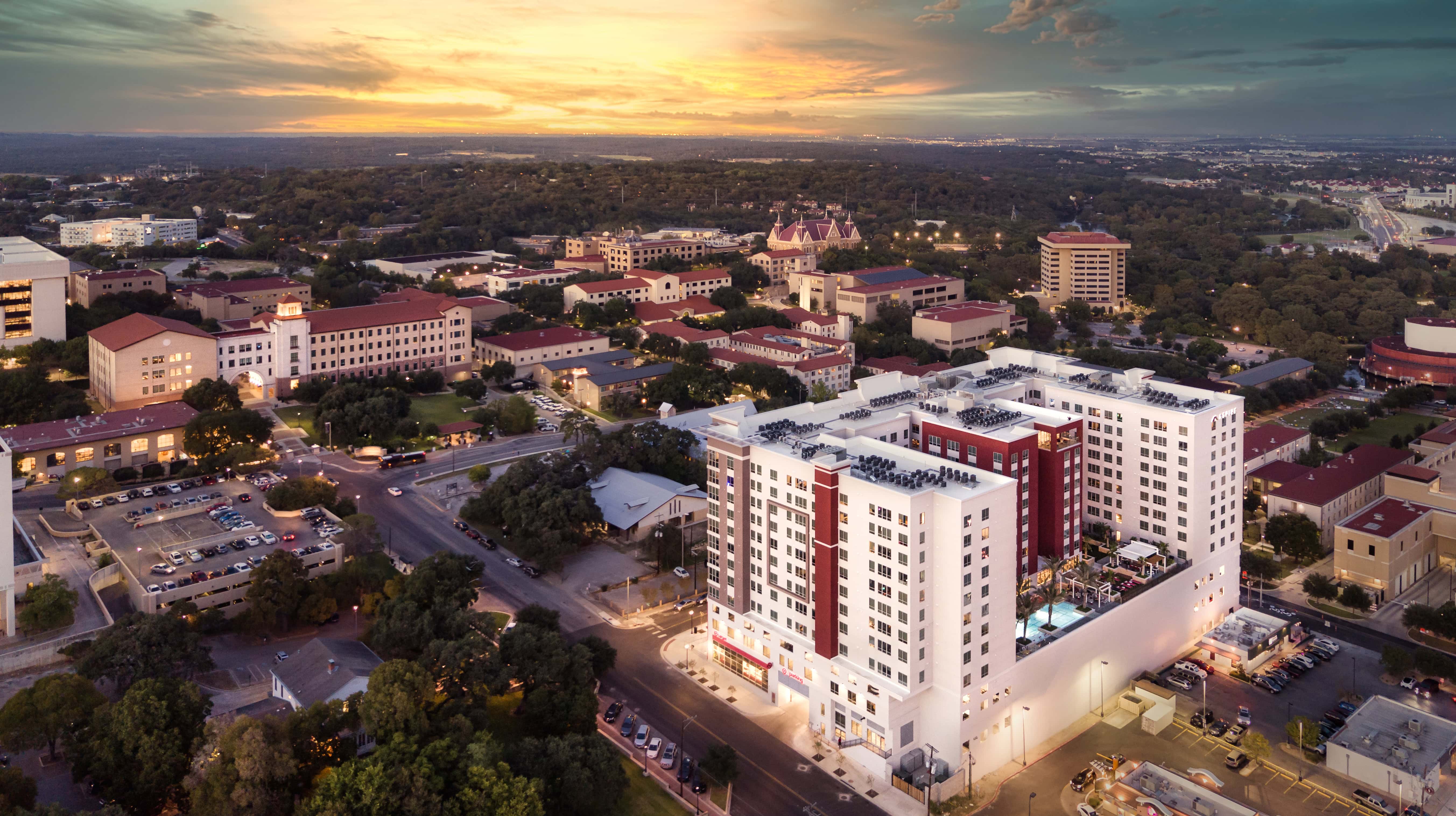 Aerial view of a city during sunset, featuring a blend of modern and traditional architecture.