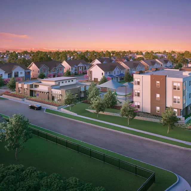 Aerial view of a modern suburban neighborhood at sunset, featuring a mix of residential homes and buildings, with green landscaping and a serene atmosphere.