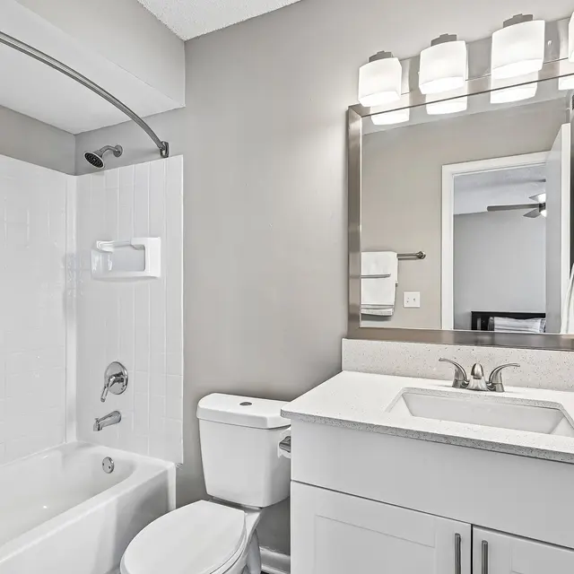 Modern Bathroom Design A modern bathroom featuring a bathtub, shower, toilet, and vanity with a mirror overhead lighting.