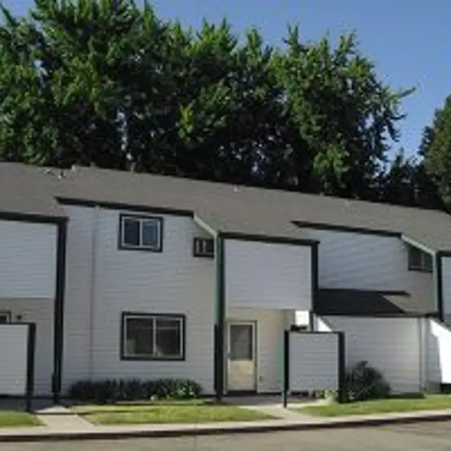 Apartment Building Exterior Exterior view of a two-story apartment building with multiple units under a clear blue sky.
