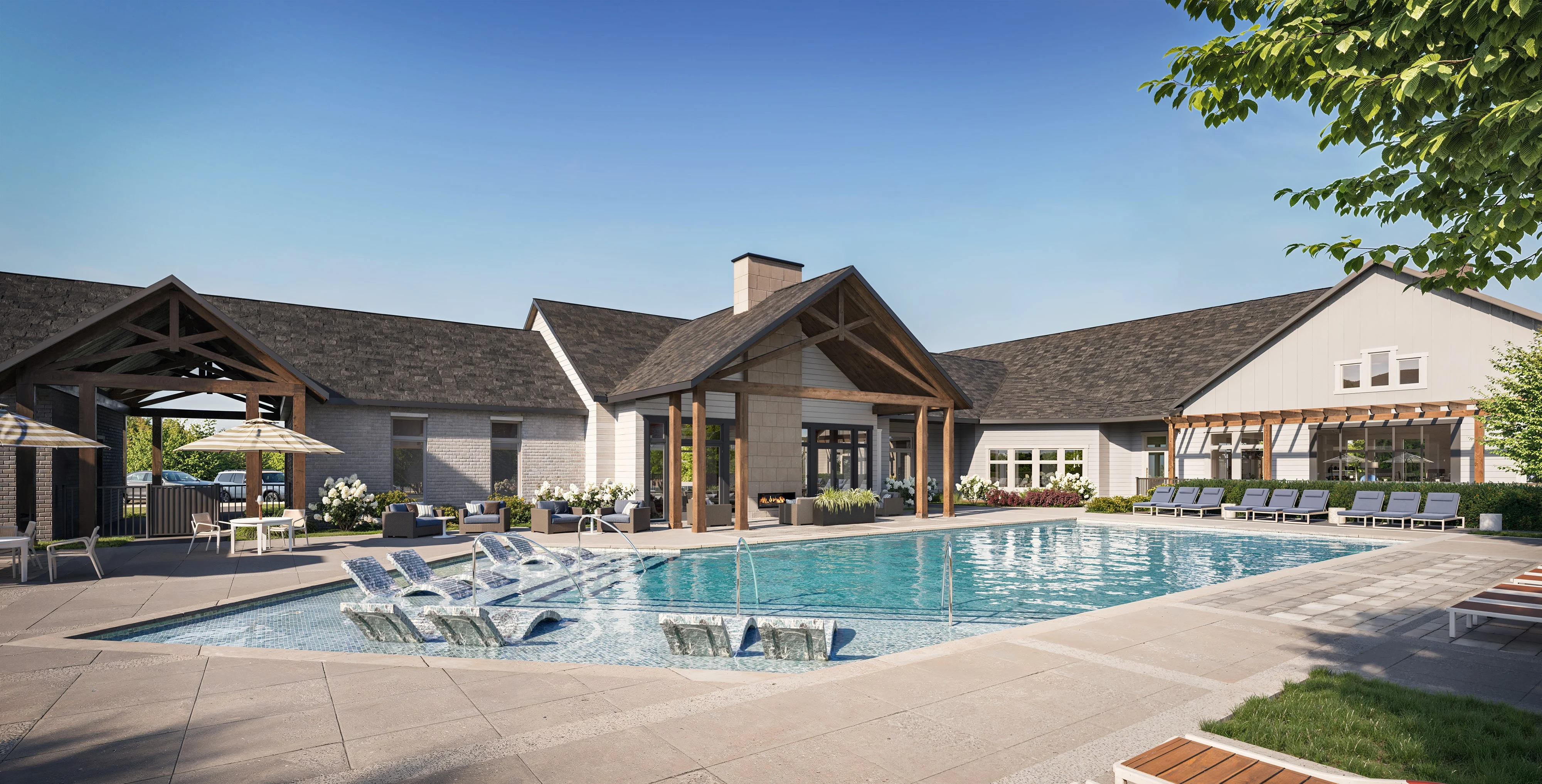 A modern pool area featuring a large swimming pool surrounded by lounge chairs, with a clubhouse in the background and clear blue skies above.