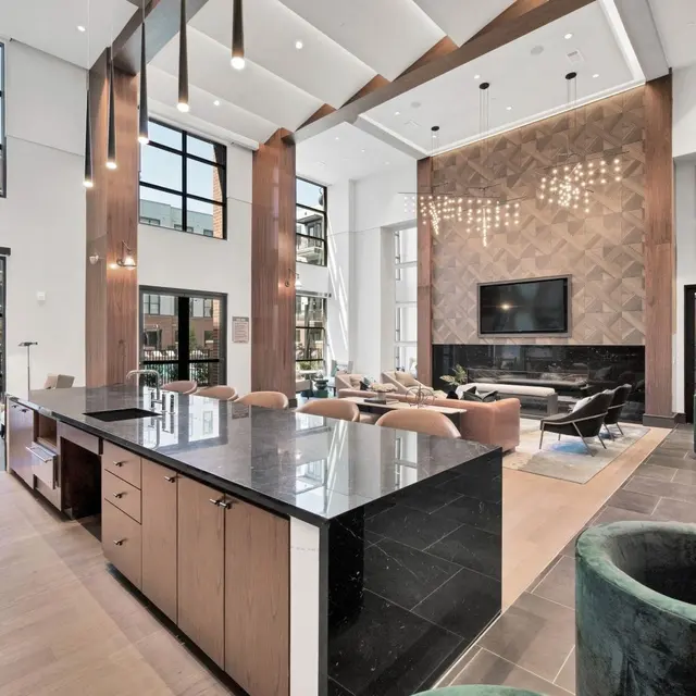 Modern Living Area A spacious modern living area featuring large windows, a high ceiling, a fireplace, and stylish furniture.