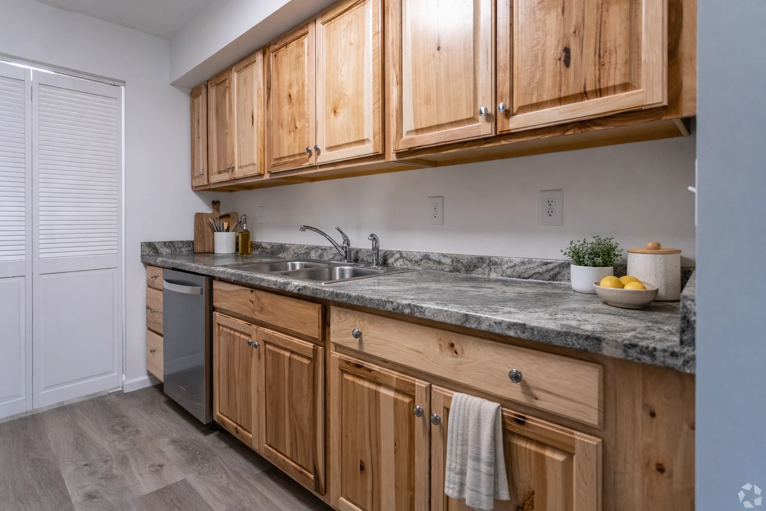 Stylish Modern Kitchen A contemporary kitchen featuring wooden cabinets, stainless steel appliances, and a granite countertop with decorative items.