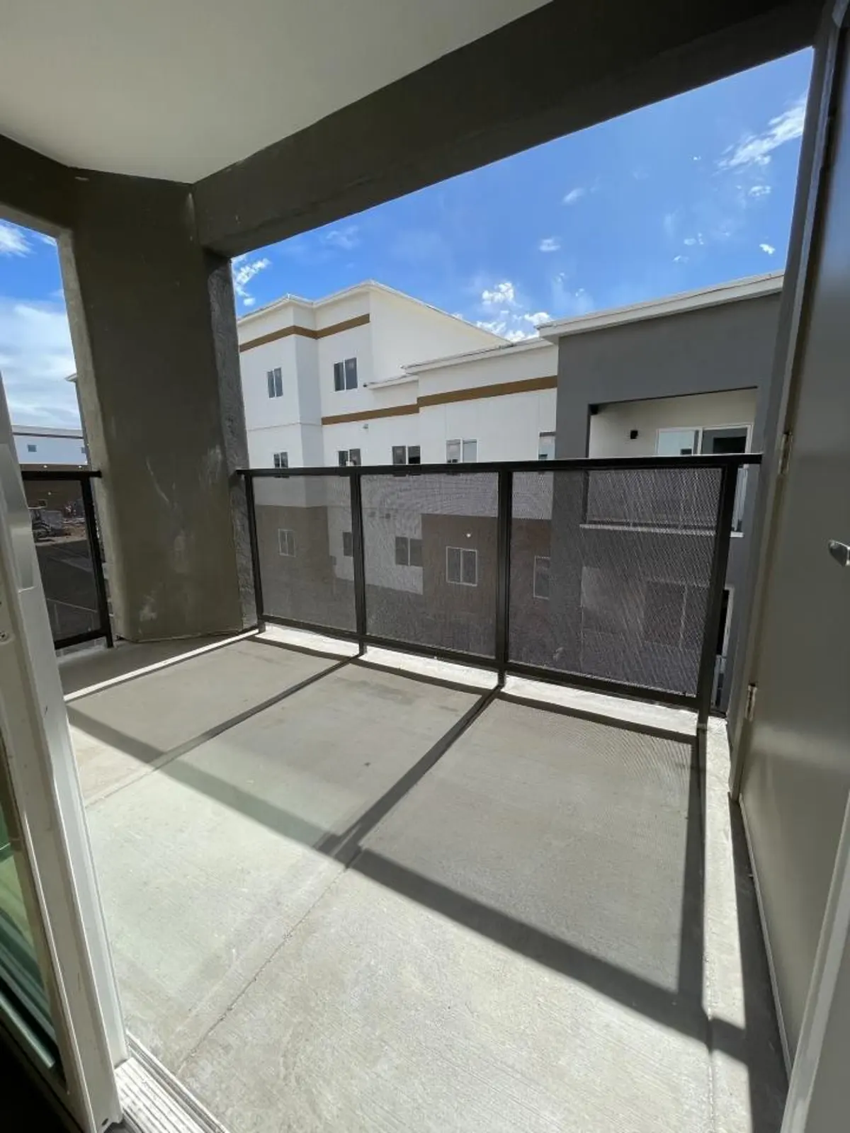 Covered balcony with railing.