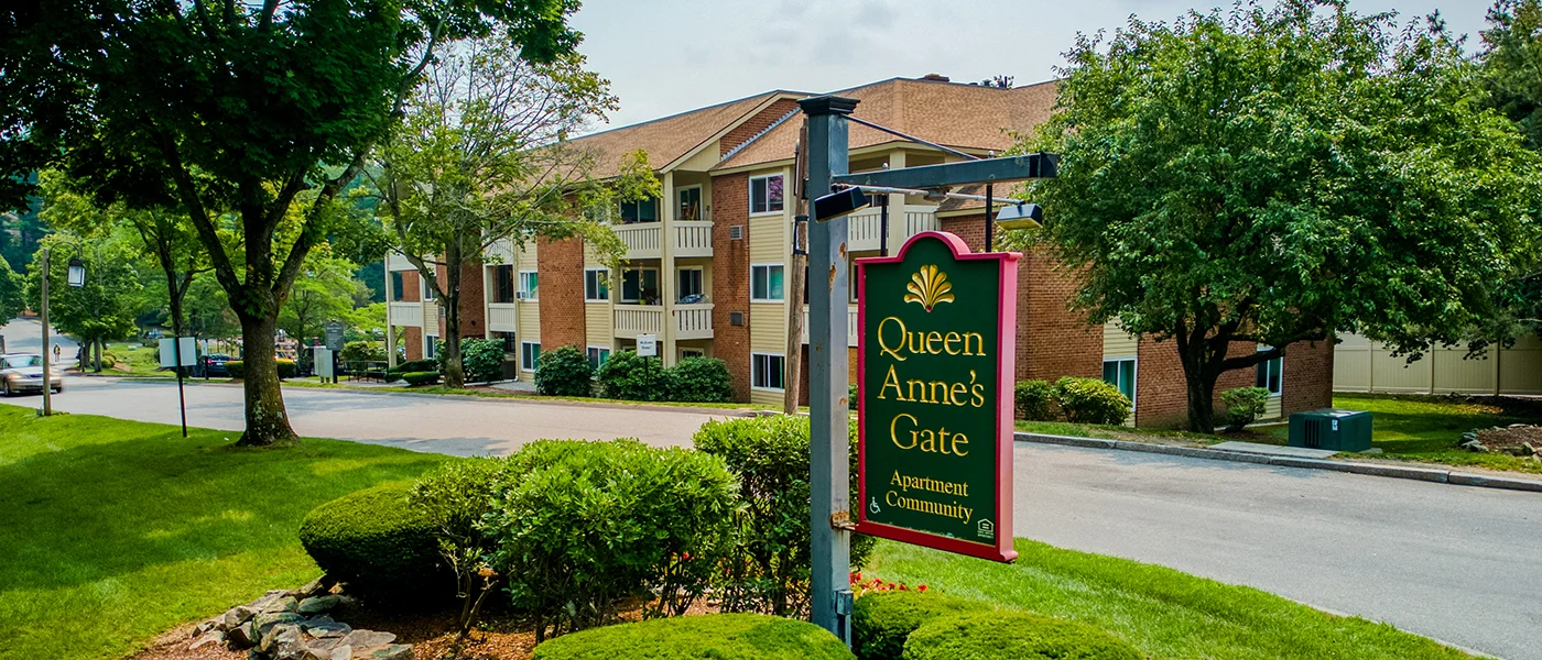 Queen Anne's Gate Apartment Community Exterior view of the Queen Anne's Gate apartment community, featuring a sign and well-maintained landscaping.