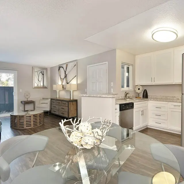 Modern apartment interior featuring an open layout with a dining area, kitchen, and living space.