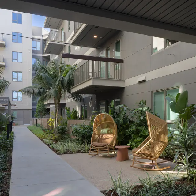 Modern Apartment Courtyard A modern apartment courtyard featuring tropical plants, pathways, and seating areas.