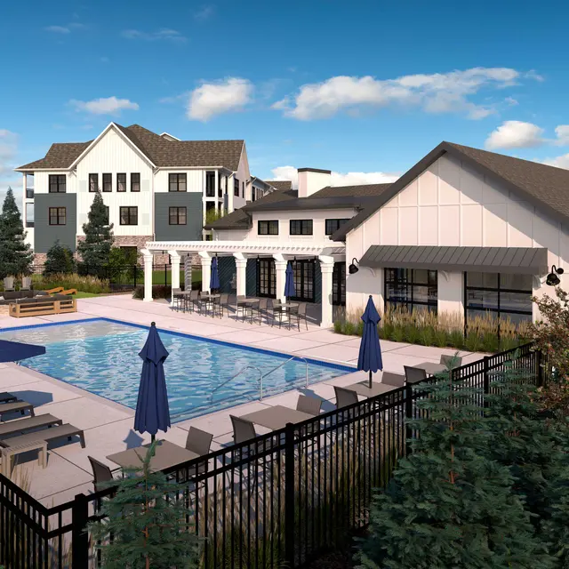 An outdoor pool area featuring a swimming pool surrounded by lounge chairs and umbrellas, with a modern building in the background.