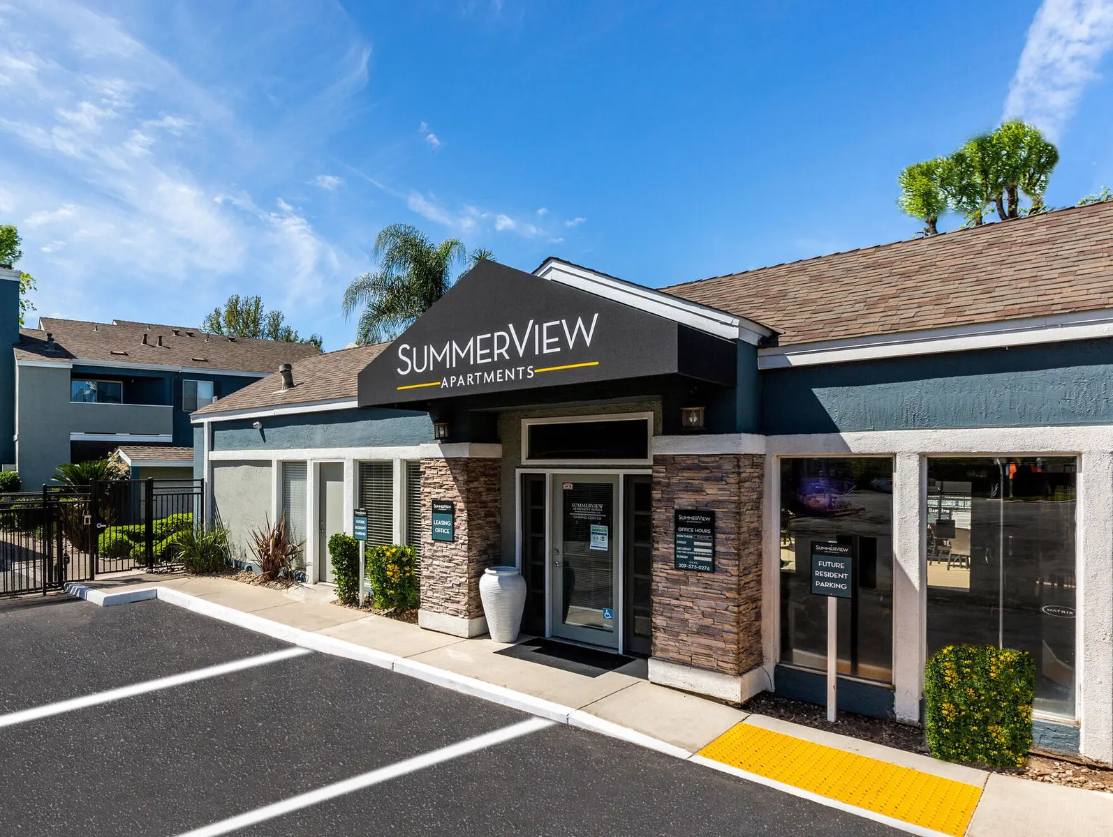 Exterior view of Summerview Apartments with a sign and landscaped surroundings.