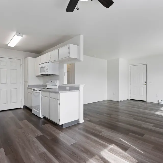 Modern Kitchen in Open Concept Design A spacious kitchen with modern design, featuring white cabinets, stainless steel appliances, and a seamless floor.
