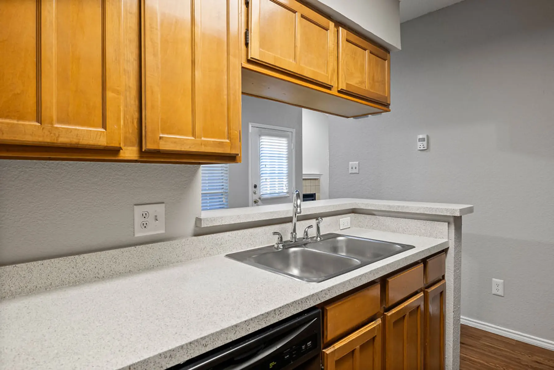 Modern Kitchen Interior A modern kitchen featuring wooden cabinets and a double sink with a countertop.